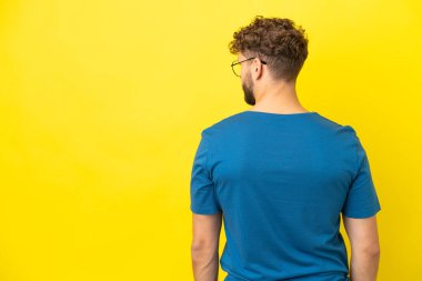 Sarı arka planda izole edilmiş yakışıklı, beyaz bir adam.