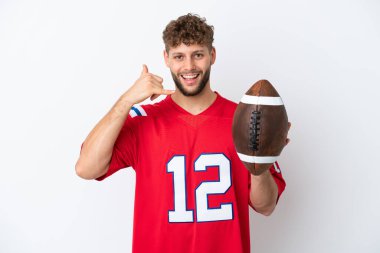 Beyaz arka planda ragbi oynayan beyaz bir adam telefon jesti yapıyor. Bana geri dönüş işareti ver.