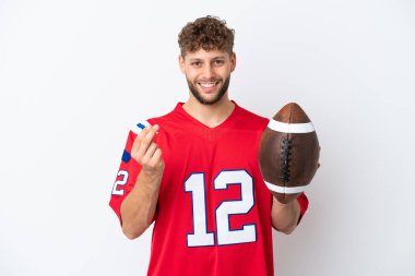 Beyaz arka planda ragbi oynayan beyaz bir adam para hareketi yapıyor.