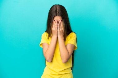 Küçük kız, yorgun ve hasta bir ifadeyle soyutlanmış mavi arka plan