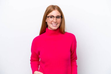 Genç kızıl saçlı kadın beyaz arka planda yalnız gülüyor.