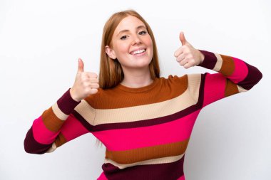 Beyaz arka planda izole edilmiş genç, kızıl saçlı bir kadın baş parmak işareti yapıyor.