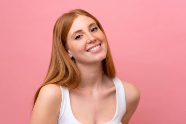 Genç kızıl saçlı kadın pembe arka planda izole edilmiş.