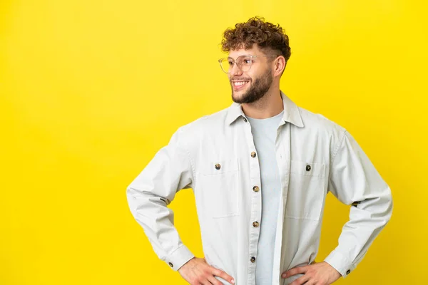Young Handsome Caucasian Man Isolated Yellow Background Posing Arms Hip — Stock Photo, Image