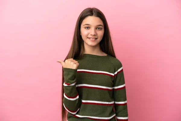 Klein Meisje Geïsoleerde Roze Achtergrond Wijzend Naar Zijkant Een Product — Stockfoto