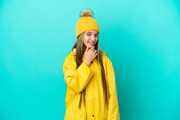 Niña Usando Abrigo Impermeable Sobre Fondo Azul Aislado Mirando Hacia —  Fotos de Stock