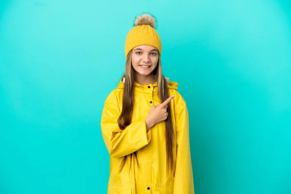 Menina Vestindo Casaco Impermeável Sobre Fundo Azul Isolado Apontando Para — Fotografia de Stock