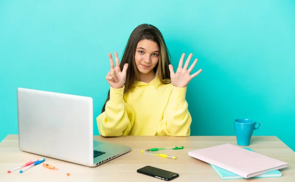 Menina Uma Mesa Com Laptop Sobre Fundo Azul Isolado Contando — Fotografia de Stock