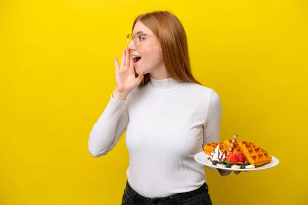 Young Redhead Woman Holding Waffles Isolated Yellow Background Shouting Mouth — Stock Photo, Image
