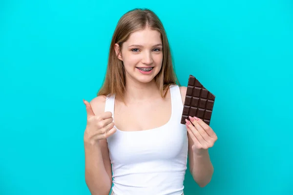 Teenager Rusky Dívka Izolované Modrém Pozadí Čokoládovou Tabletu Palcem Nahoru — Stock fotografie