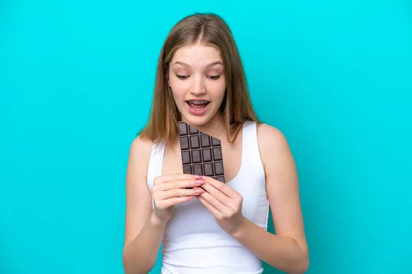 Teenager Rusky Dívka Izolované Modrém Pozadí Jíst Čokoládové Tablety — Stock fotografie