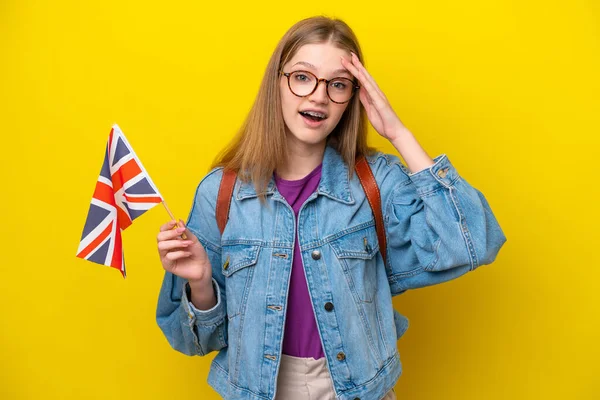 举着英国国旗的俄罗斯少女 背景为黄色 表情令人惊讶 — 图库照片