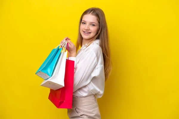 Adolescente Rusa Chica Aislado Amarillo Fondo Sosteniendo Bolsas Compras Sonriendo — Foto de Stock