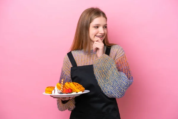 Adolescente Rusa Chica Sosteniendo Waffles Aislado Sobre Fondo Rosa Mirando —  Fotos de Stock