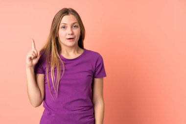 Pembe arka planda izole edilmiş genç Ukraynalı kız parmağını kaldırarak çözümü bulmaya çalışıyor.
