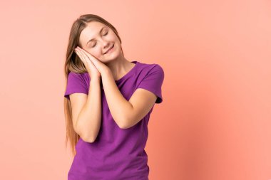 Pembe arka planda izole edilmiş genç Ukraynalı kız uyku jesti yapıyor.