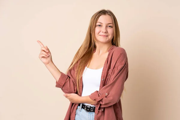 Adolescente Ucraniana Menina Isolada Fundo Bege Feliz Apontando Para Cima — Fotografia de Stock