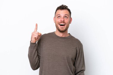 Beyaz arka planda izole edilmiş genç Brezilyalı adam yukarı bakıyor ve şaşırıyor.