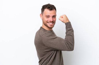 Beyaz arka planda izole edilmiş genç Brezilyalı adam güçlü bir jest yapıyor.