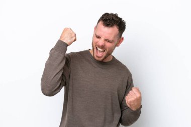 Genç Brezilyalı izole edilmiş beyaz arka planda zaferi kutluyor.