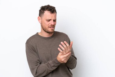 Genç Brezilyalı adam beyaz arka planda izole edilmiş, ellerinde acıdan muzdarip.