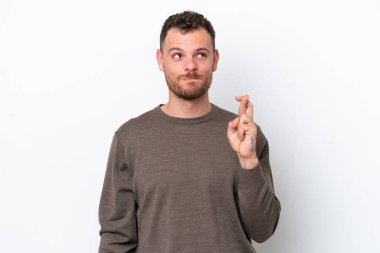 Genç Brezilyalı adam beyaz arka planda izole edilmiş, şans diliyor ve en iyisini diliyor.