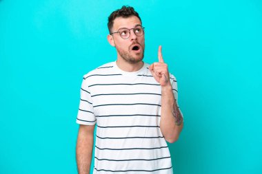 Genç Brezilyalı bir adam mavi arka planda izole edilmiş.