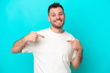 Genç Brezilyalı adam mavi arka planda soyutlanmış gururlu ve kendini beğenmiş.