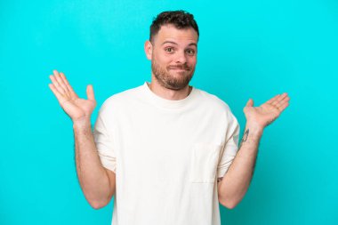 Mavi arka planda izole edilmiş Brezilyalı genç şüpheli hareketler yapıyor.