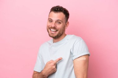 Pembe arka planda izole edilmiş yara bandı takan genç Brezilyalı adam.