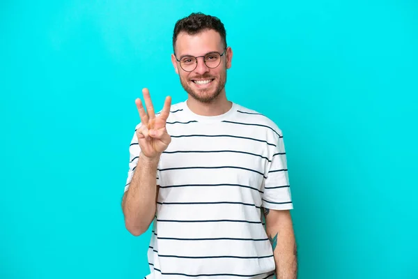 Młody Brazylijczyk Człowiek Odizolowany Niebieskim Tle Szczęśliwy Liczyć Trzy Palce — Zdjęcie stockowe