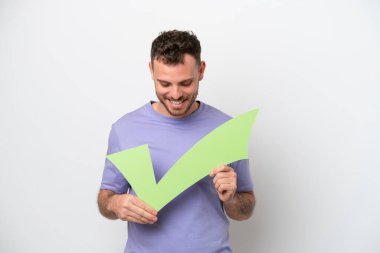 Genç Brezilyalı bir adam beyaz arka planda izole edilmiş. Elinde bir çek simgesi var ve ona bakıyor.