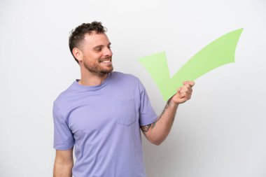 Beyaz arka planda izole edilmiş Brezilyalı genç bir adam elinde mutlu bir ifadeyle bir çek simgesi tutuyor.