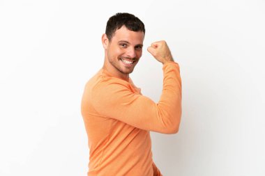 İzole edilmiş beyaz arka planda Brezilyalı bir adam güçlü bir hareket yapıyor.