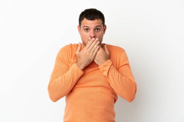 İzole edilmiş beyaz arka planı olan Brezilyalı adam elleriyle ağzını kapatıyor.