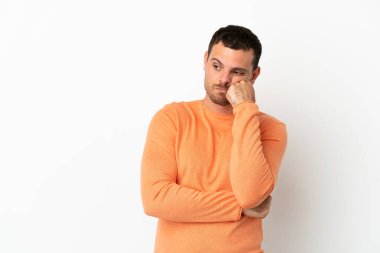 Brezilyalı bir adam soyutlanmış beyaz bir arka plan ve yorgun ve sıkılmış bir ifade