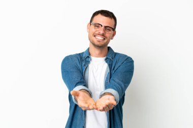 İzole edilmiş beyaz arkaplan üzerinde Brezilyalı bir adam bir ilan vermek için avucunda hayali bir metin tutuyor.