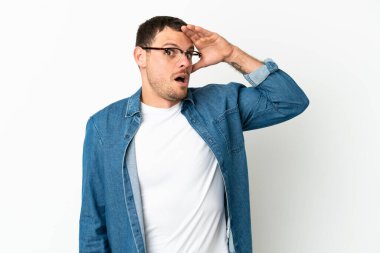 İzole edilmiş beyaz arka plan üzerinde Brezilyalı bir adam yana bakarken sürpriz jest yapıyor.