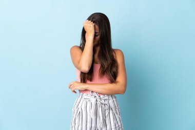 Genç Brezilyalı kadın mavi arka planda izole edilmiş baş ağrısıyla