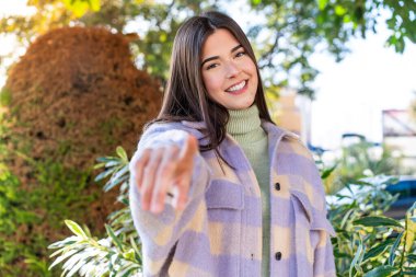 Parktaki genç Brezilyalı kadın kendine güvenen bir ifadeyle seni işaret ediyor.