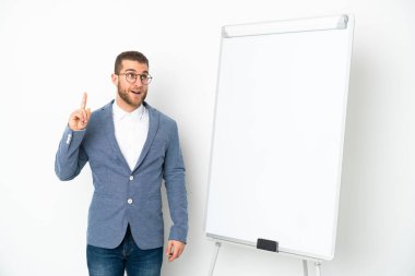 Beyaz arka planda izole edilmiş beyaz panoda sunum yapan genç bir iş kadını, suçluyu işaret eden bir fikir düşünüyor.