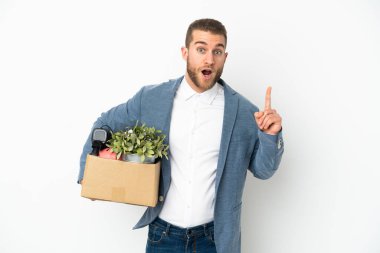 Beyaz arka planda izole edilmiş şeylerle dolu bir kutuyu kaldırırken genç beyaz tenli hareket ediyor.
