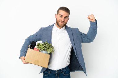 Beyaz arka planda izole edilmiş eşyalarla dolu bir kutuyu alarak güçlü bir hareket yapan genç Kafkasyalı.