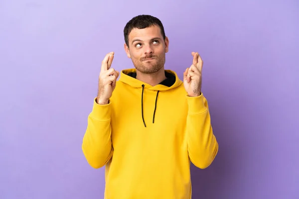 Hombre Brasileño Sobre Fondo Púrpura Aislado Con Dedos Cruzando Deseando —  Fotos de Stock