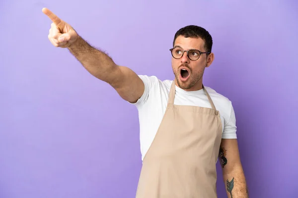 Garçom Restaurante Brasileiro Sobre Fundo Roxo Isolado Apontando Para Longe — Fotografia de Stock