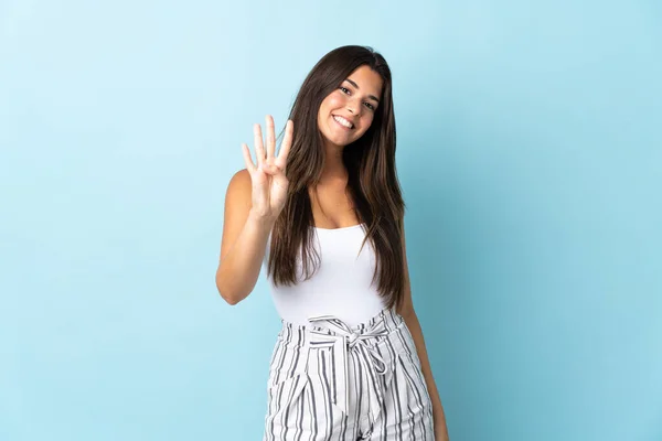若いブラジル人女性は青の背景に幸せと指で4を数える — ストック写真