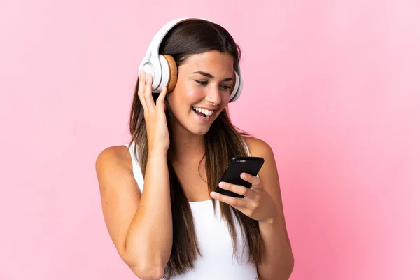 Νεαρή Βραζιλιάνα Απομονωμένη Ροζ Φόντο Ακούγοντας Μουσική Κινητό Και Τραγουδώντας — Φωτογραφία Αρχείου