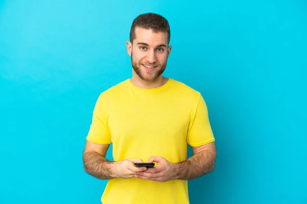 Young Handsome Caucasian Man Isolated Blue Background Sending Message Mobile — Stock Photo, Image