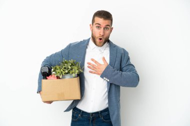 Beyaz arka planda izole edilmiş eşyalarla dolu bir kutuyu alırken genç Kafkasyalı hamle yapıyor sağa bakarken şaşırıp şoka uğruyor.