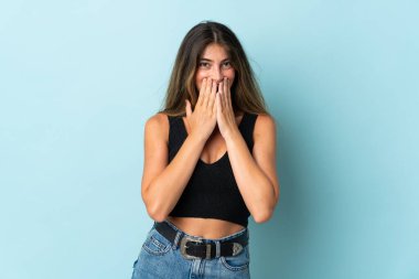 Genç beyaz kadın mavi arka planda izole edilmiş mutlu ve gülümseyen elleri ve ağzı kapalı.